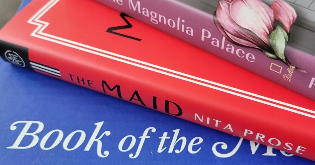 Blue Book of the Month Box with Red Maid book stacked on top