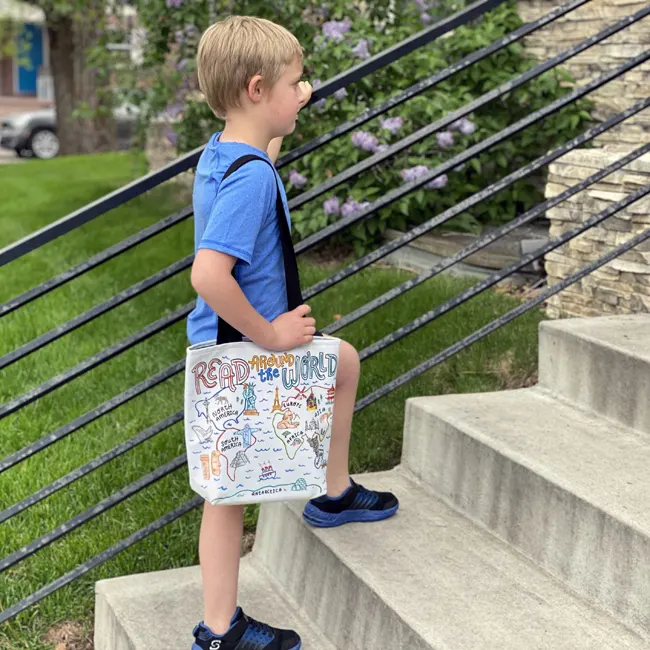 boy carrying illustrated world map library tote bag
