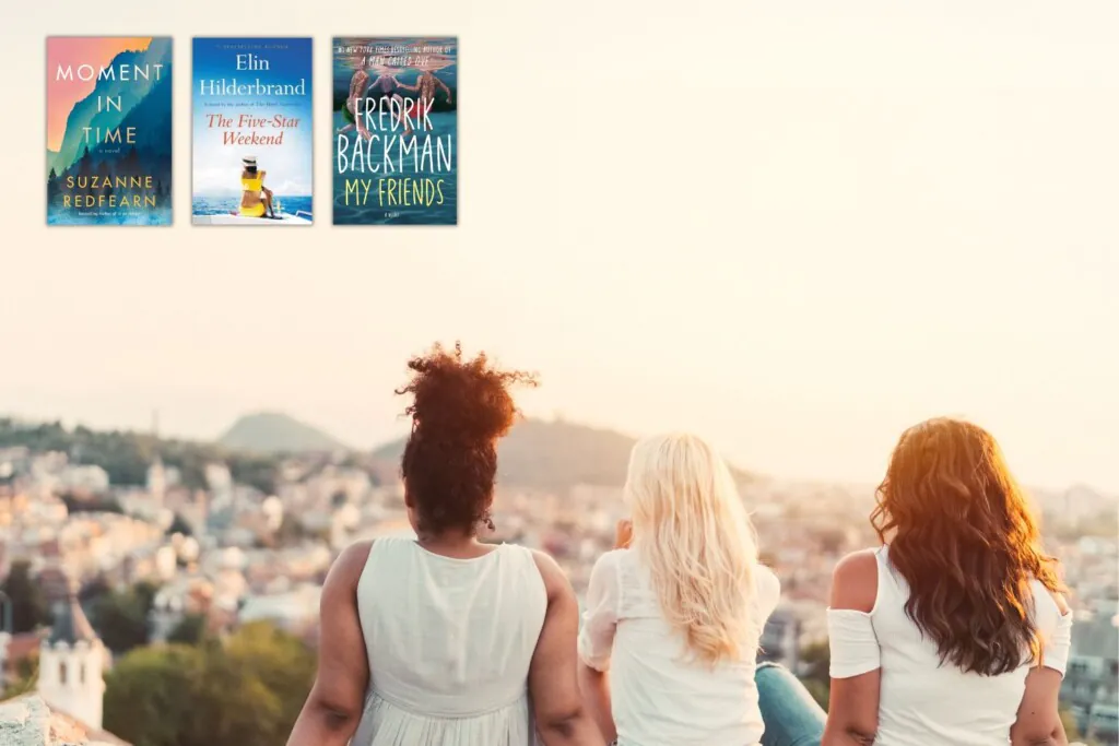 Three female friends from behind as they sit overlooking a vista