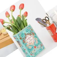 Three titled photos of a bamboo bathtub tray, book scented candles, and a ceramic book vase filled with tulips