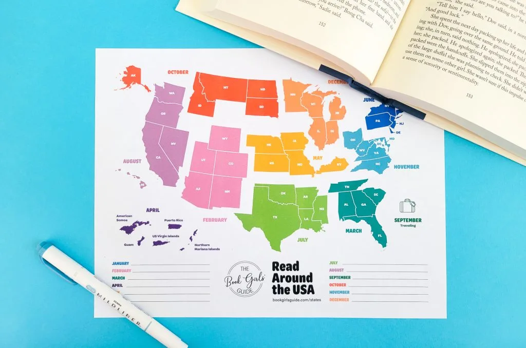 Photo of the printable US map for the Book Girls' Guide Read Around the USA challenge with an open book in the top right corner and a pen in the bottom left corner.