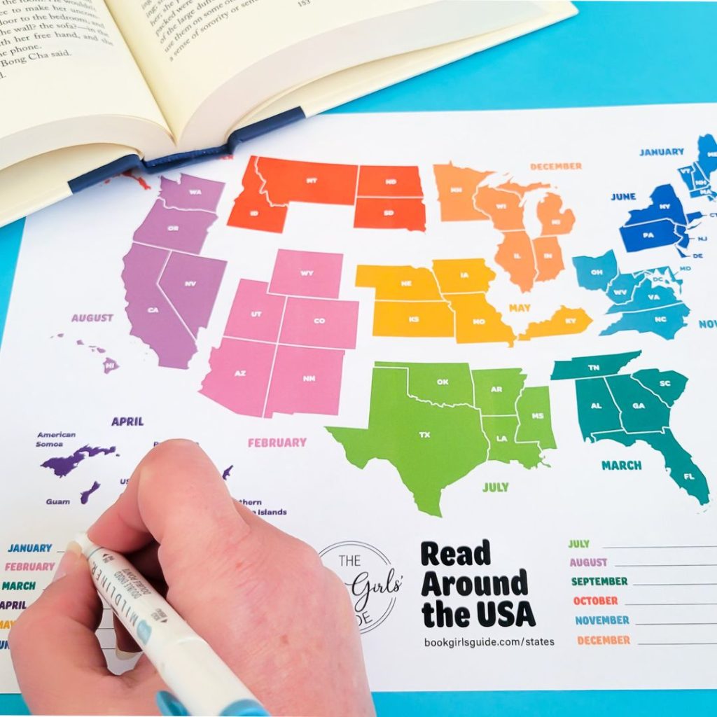 Hand holding a pen filling out the Read Around the USA reading challenge printable book tracker