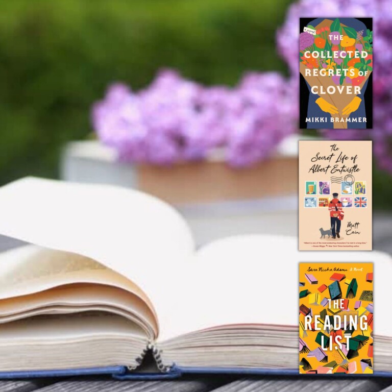 Open book on a wood table with purple flowers in the background and three book covers down the right side of the image