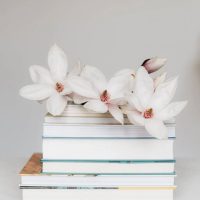 stack of books with flowers on top