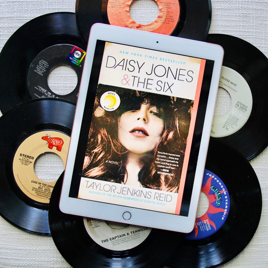 Cover of Daisy Jones and The Six box on an iPad laying on top of six vinyl records.