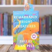 Book cover for Remarkably Bright Creatures featuring bright colors and an orange octopus, sitting on a table in front of a bookcase