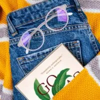 Fall sweater and jeans laying flat with partial fall book shown