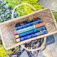 4 books in a wicker basket on a garden path
