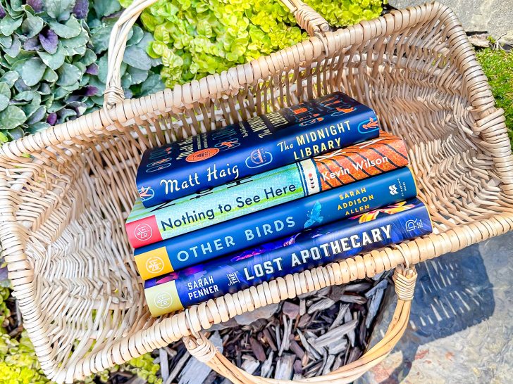 4 books in a wicker basket on a garden path