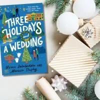 Wintery background in white and gold with the book Three Holidays and Wedding sitting to to the left