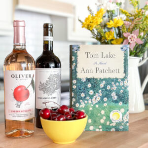 Tom Lake book & wine bottles and a bowl of cherries