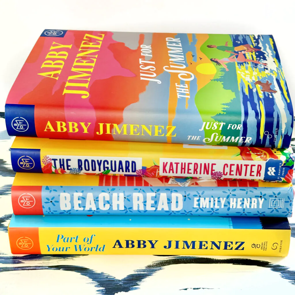 Stack of books featuring books by Abby Jimenez and by authors like Abby Jimenez