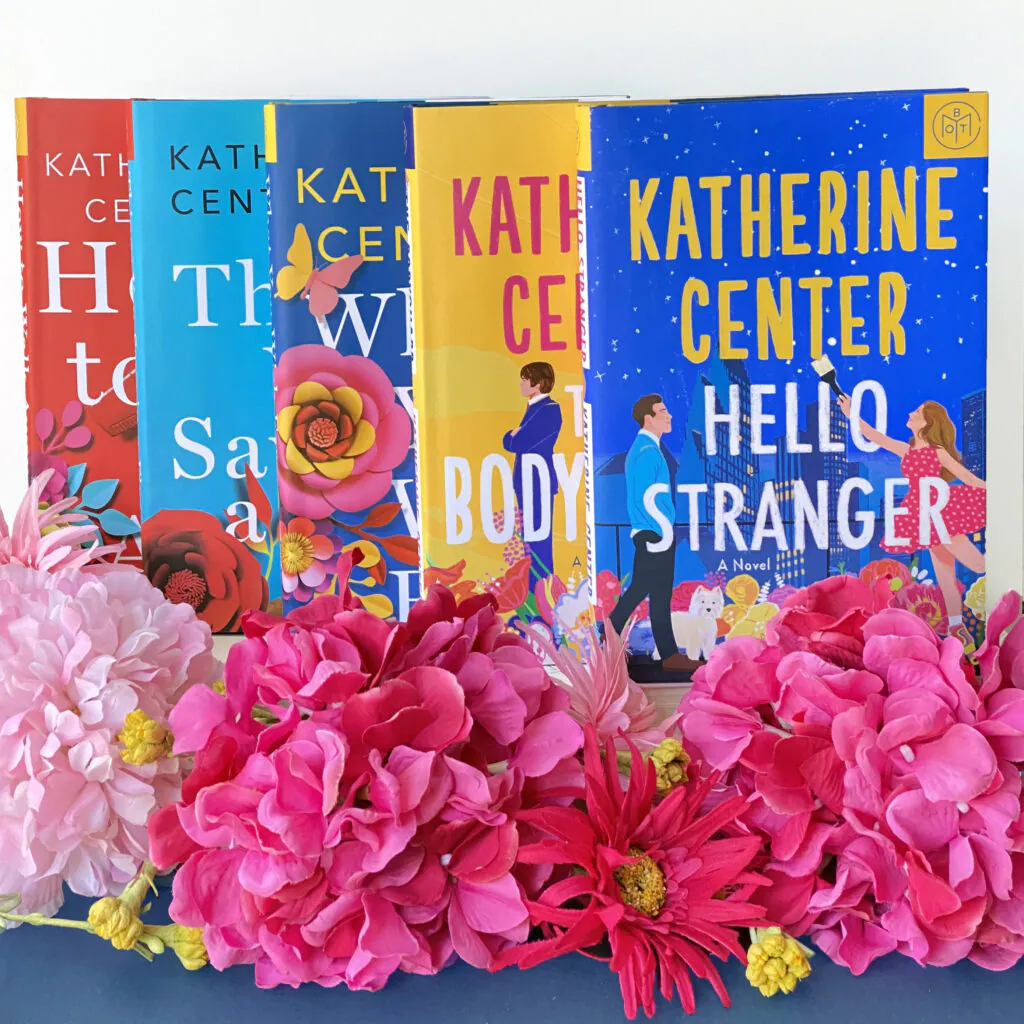 Five Katherine Center books standing side by side with pink flowers in front