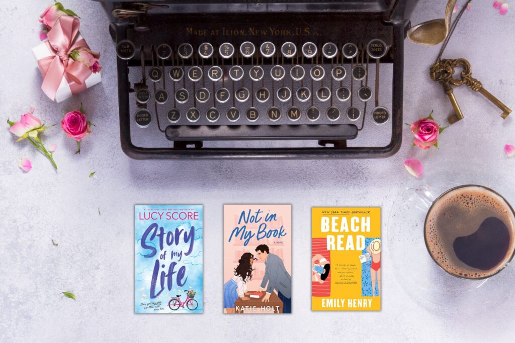 Vintage black typewriter on a light background with pink roses, a cup of coffee, and covers of three romance books about writers