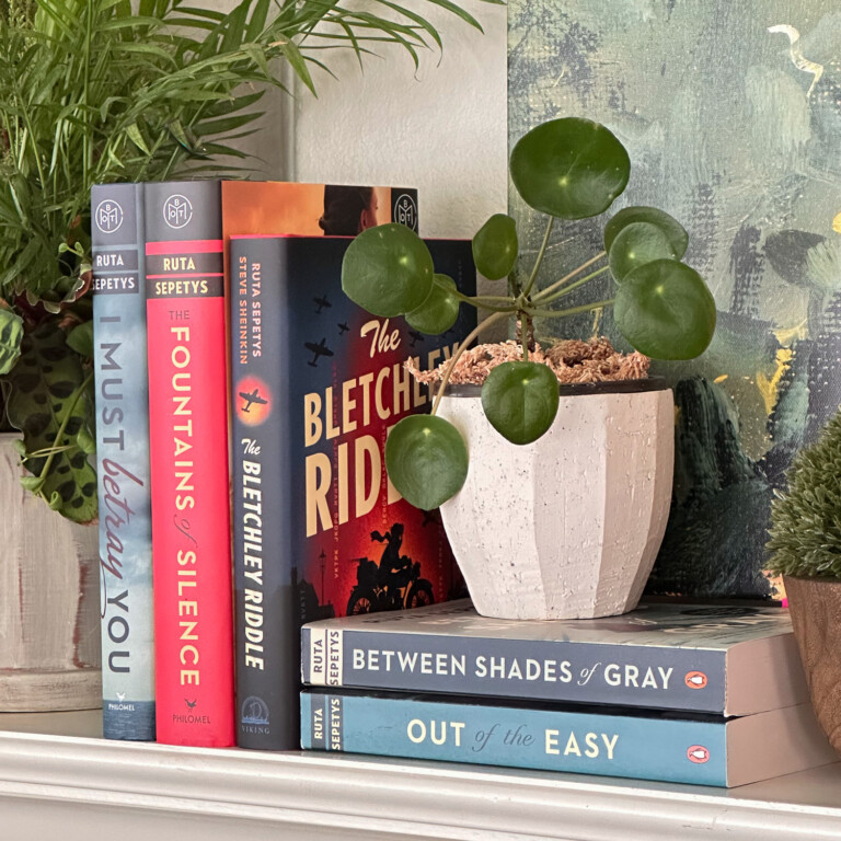 Ruta Sepetys Books on Fireplace mantel with plants