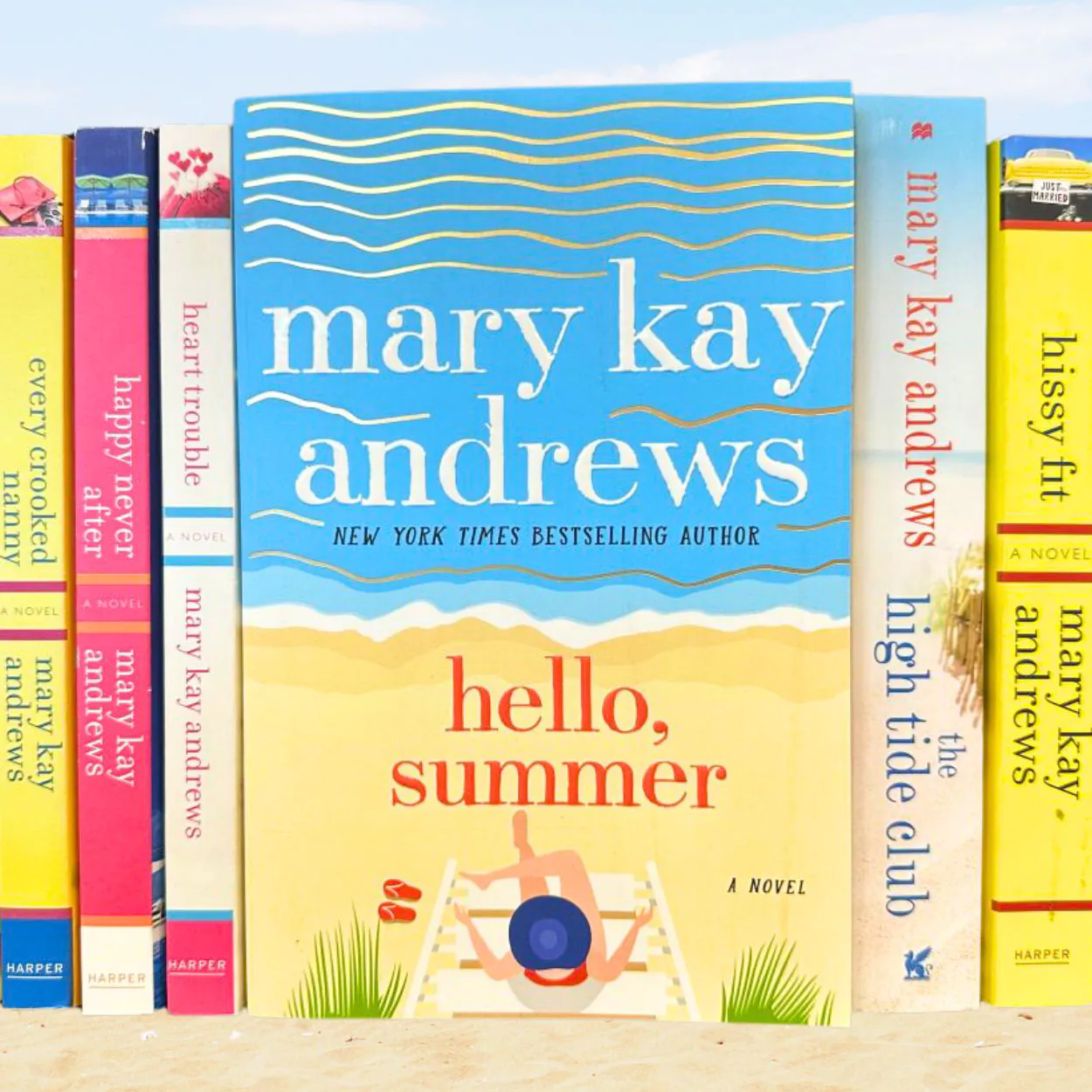 A row of Mary Kay Andrews book spines with Hello Summer facing forward in the center