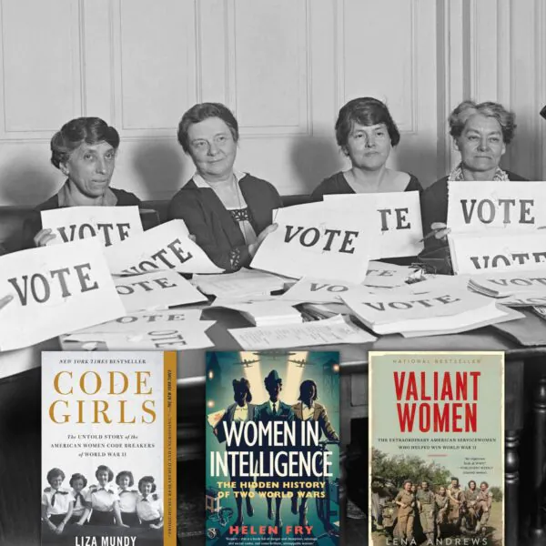 Black and white photo of suffragettes holding up vote signs at a table