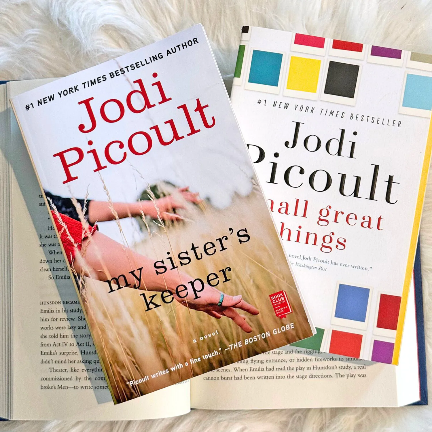 Two of Jodi Picoult best books stacked on top of an open book. My Sister's Keeper and Small Great Things Book Covers