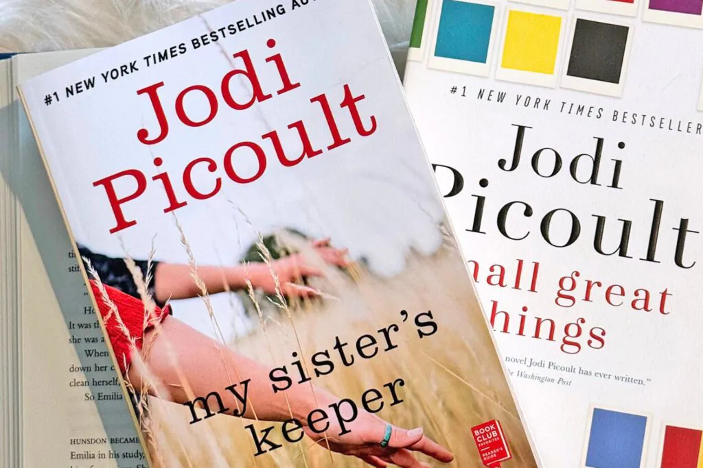 Two of Jodi Picoult best books stacked on top of an open book. My Sister's Keeper and Small Great Things Book Covers