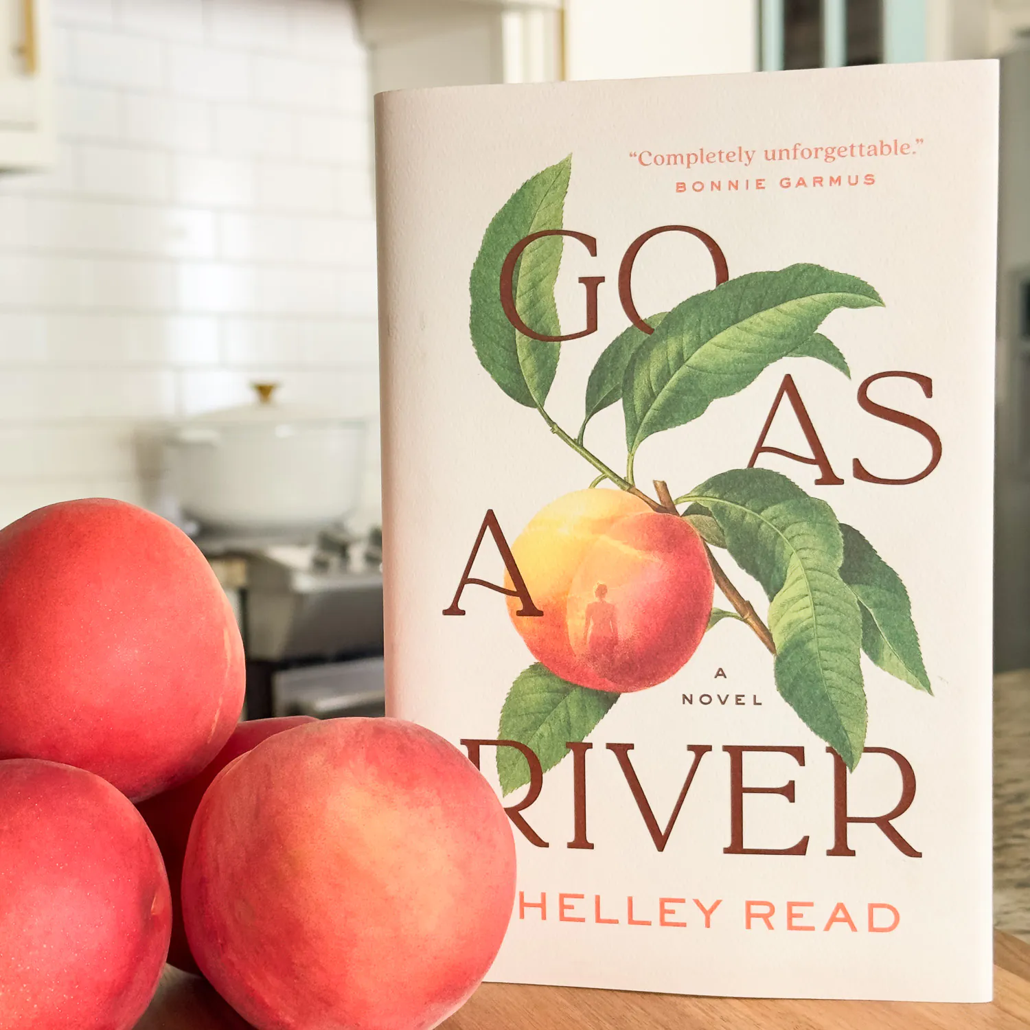 Go as a River Book cover next to a stack of peaches